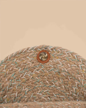 Close-up of a woven textured material with a button on a beige background
