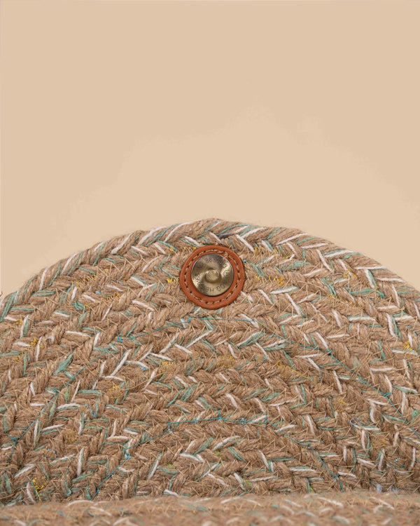 Close-up of a woven textured material with a button on a beige background