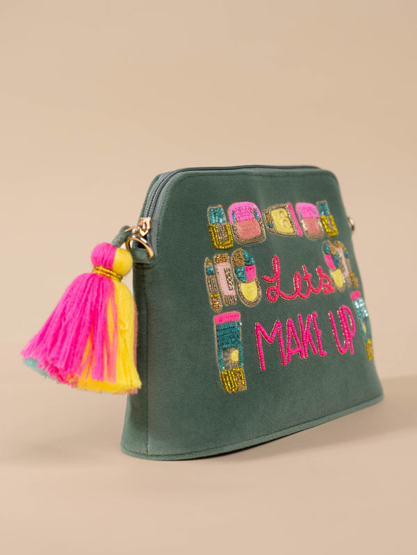 Dark green sling bag with “Let’s MAKE UP” embroidery and colorful makeup-themed illustrations