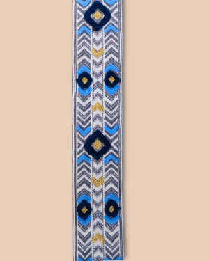 Decorative belt strap with blue and yellow geometric pattern on a beige background
