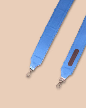 Blue strap with metal clasp on a beige background