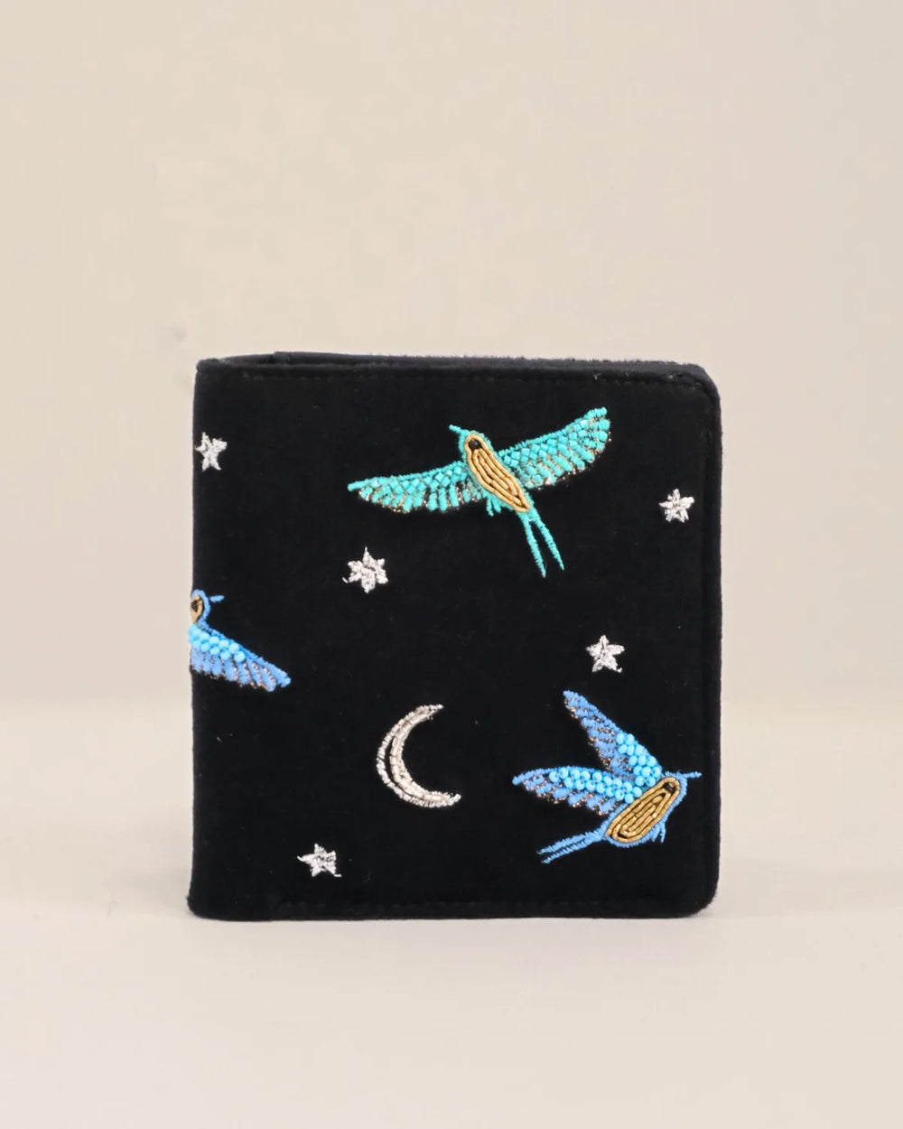 Black embroidered wallet with birds and stars on a beige background