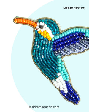 Colorful beaded lapel pin designed as a kingfisher bird, featuring turquoise, royal blue, orange, and white embroidery.