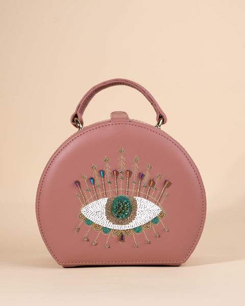 Peach box sling bag featuring evil eye motif with intricate hand embroidery, crystals, and beadwork
