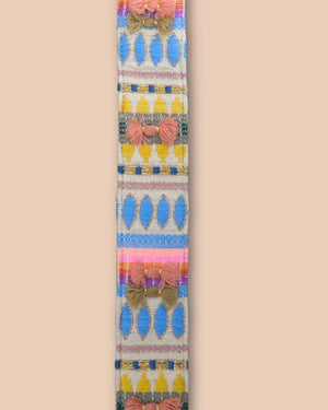 Decorative ribbon with colorful patterns and bows on a beige background