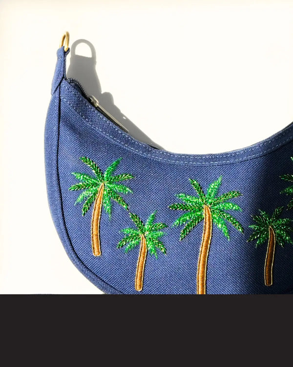 Blue visor with green palm tree designs on a white background
