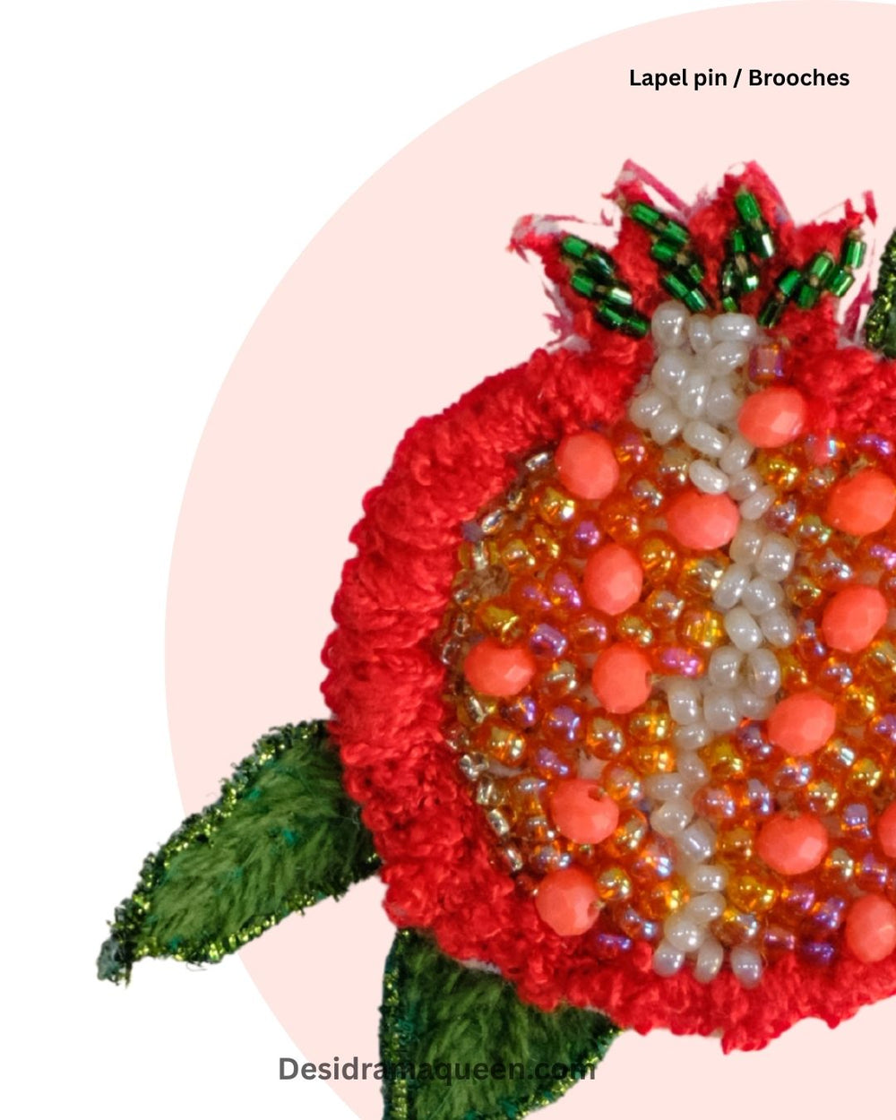 Handmade embroidered pomegranate brooch with red beadwork, green leaves, and gold accents, fruit lapel pin for jackets and bags.
