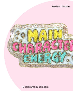 Colorful embroidered brooch with vibrant lettering ‘Main Character Energy’, handmade lapel pin for bags, jackets, and accessories.