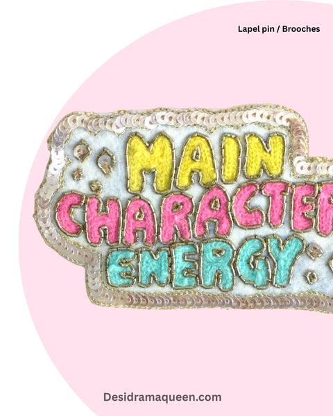 Colorful embroidered brooch with vibrant lettering ‘Main Character Energy’, handmade lapel pin for bags, jackets, and accessories.