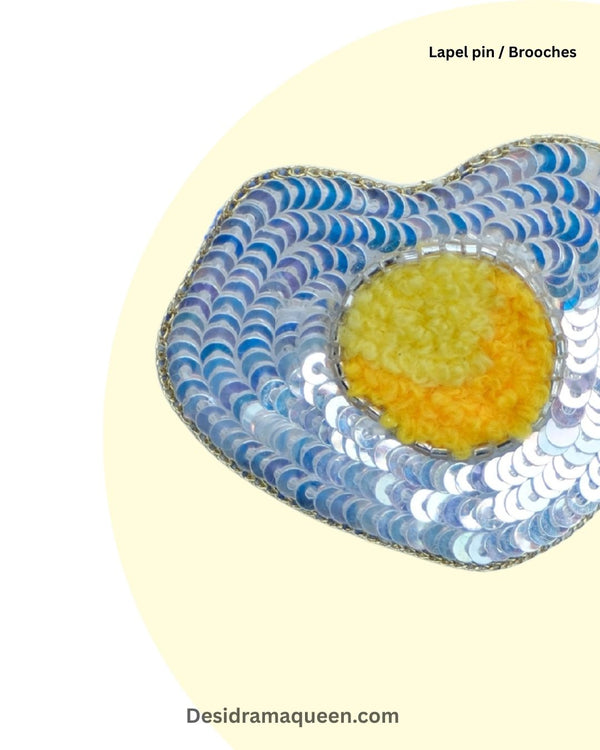 Beaded egg brooch with yellow yolk and shimmering white sequins, fun accessory for food lovers