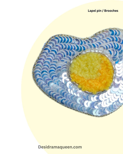 Beaded egg brooch with yellow yolk and shimmering white sequins, fun accessory for food lovers
