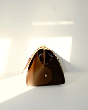 Brown handbag with gold accents on a white background