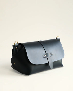 Two-toned black and gray leather bag on a light beige background
