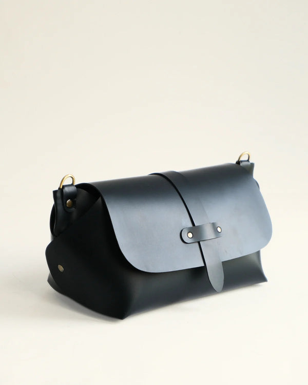 Two-toned black and gray leather bag on a light beige background