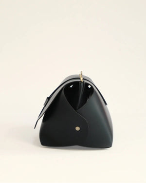 Black triangular bag on a beige background