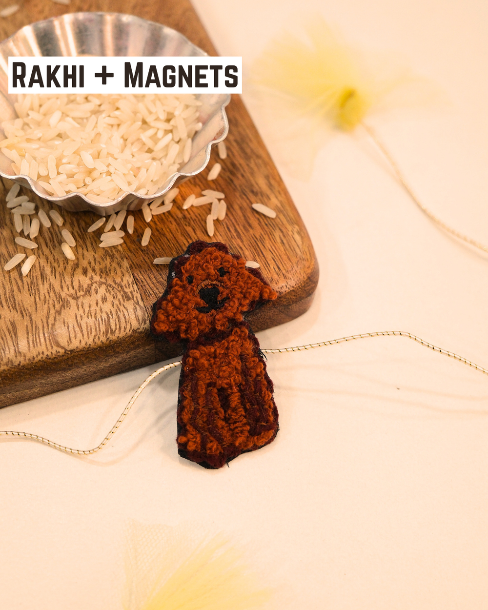 Cute Dog embroidered rakhi magnet placed beside a bowl of rice, styled for a festive Raksha Bandhan celebration.