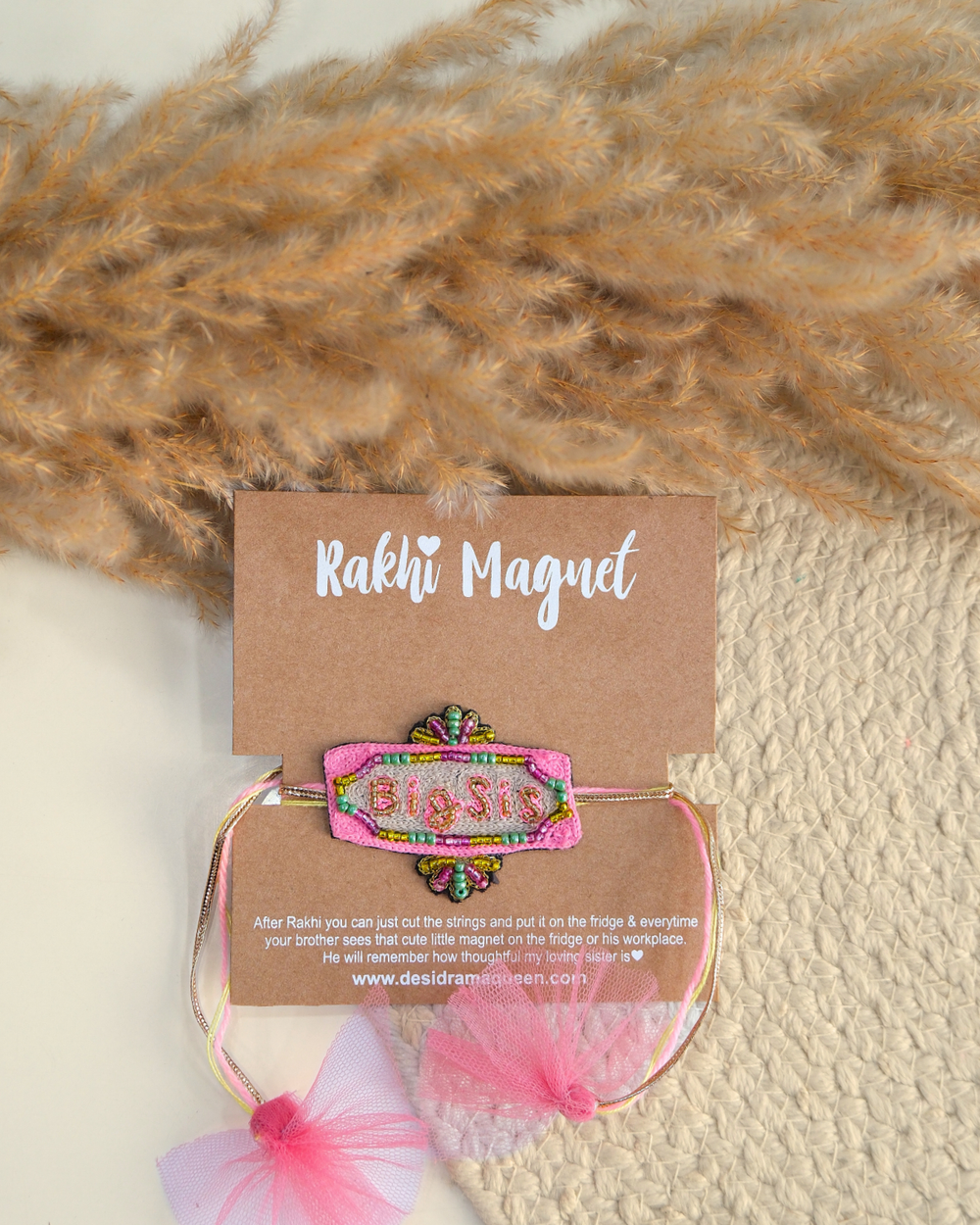 Big Sis embroidered rakhi with glitter lettering placed beside a bowl of rice for a festive Raksha Bandhan celebration.