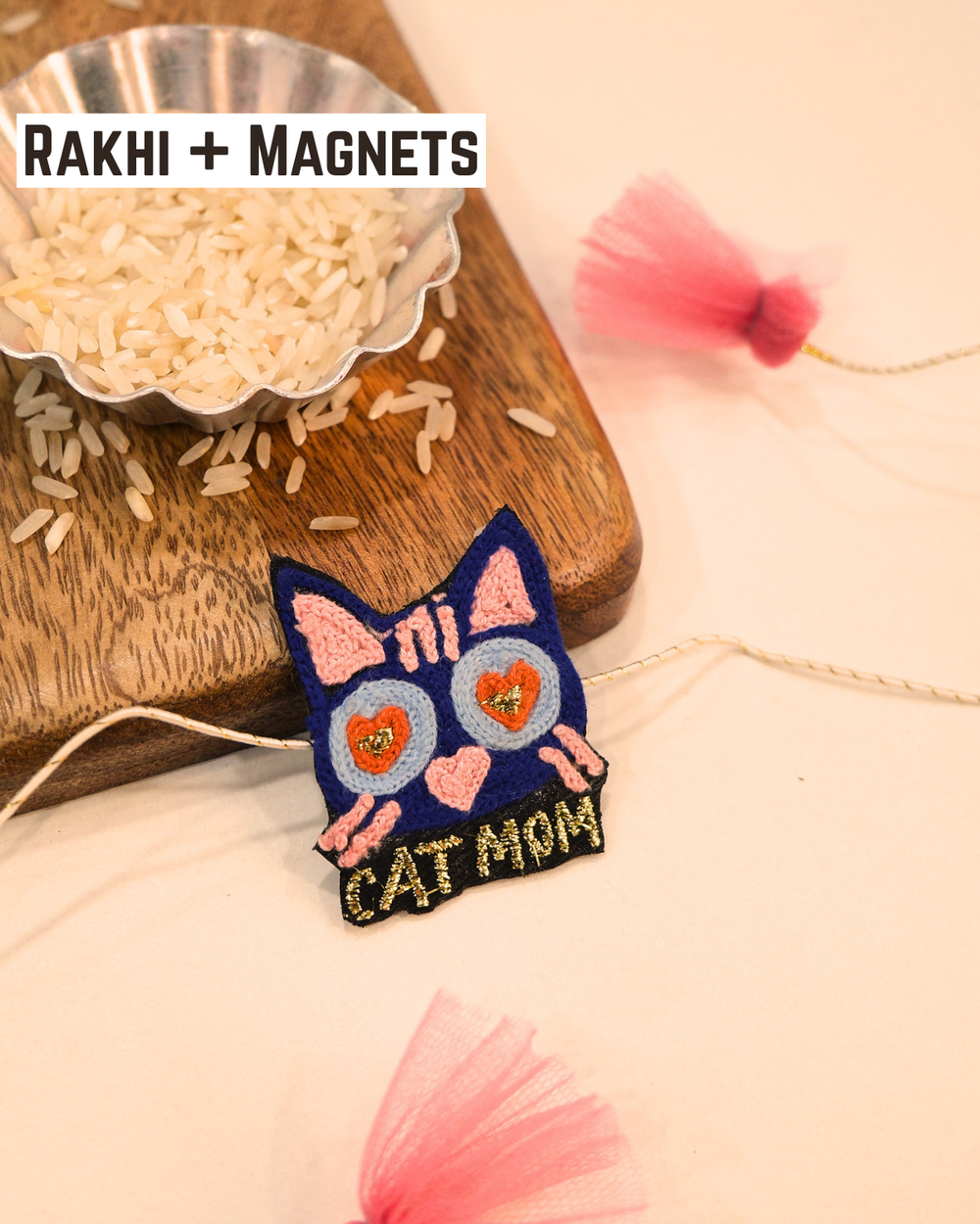 Cat Mom embroidered rakhi magnet placed beside a bowl of rice, styled for a festive Raksha Bandhan celebration.