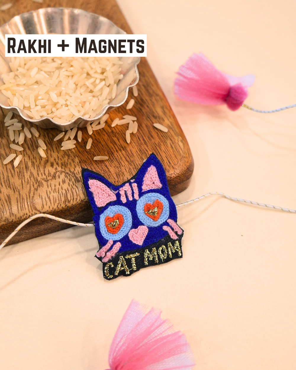 Cat Mom embroidered rakhi magnet placed beside a bowl of rice, styled for a festive Raksha Bandhan celebration.