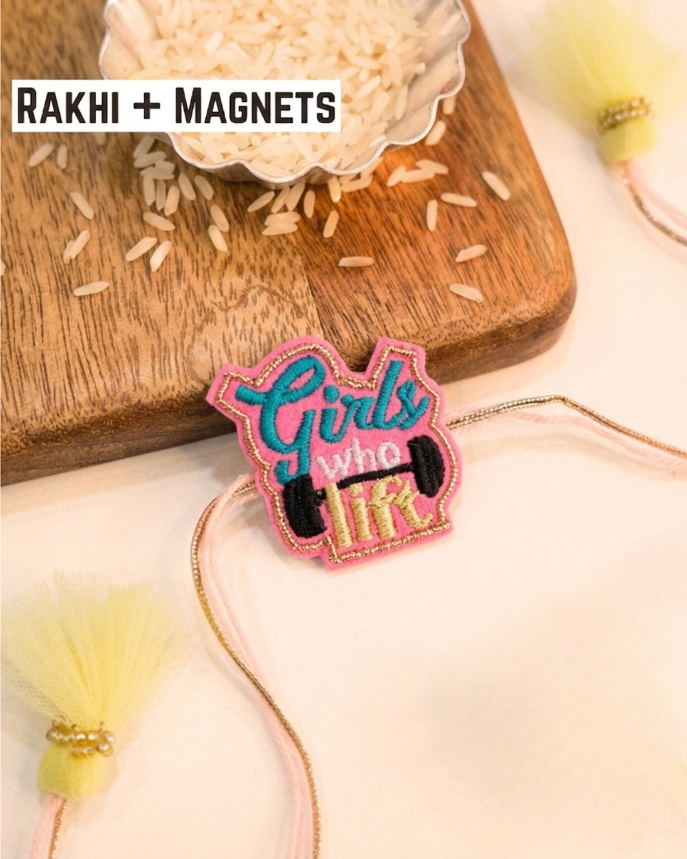 Girls Who Lift embroidered rakhi magnet placed beside a bowl of rice, styled for a festive Raksha Bandhan celebration.