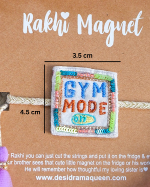 Packaged "Gym Mode On" Rakhi magnet showcased on a wooden background, highlighting a fun and unique Raksha Bandhan gift idea.