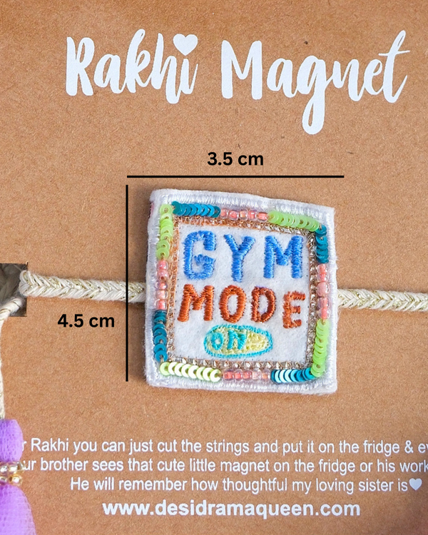 Packaged "Gym Mode On" Rakhi magnet showcased on a wooden background, highlighting a fun and unique Raksha Bandhan gift idea.
