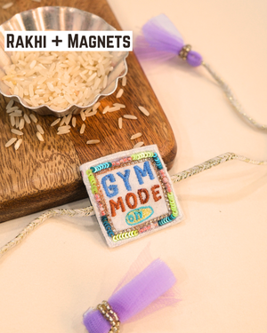 Colorful "Gym Mode On" Rakhi magnet displayed on a woden tray in rakhi set background, celebrating a fitness-loving brother.