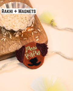 Paw Papa embroidered rakhi magnet placed beside a bowl of rice, styled for a festive Raksha Bandhan celebration.