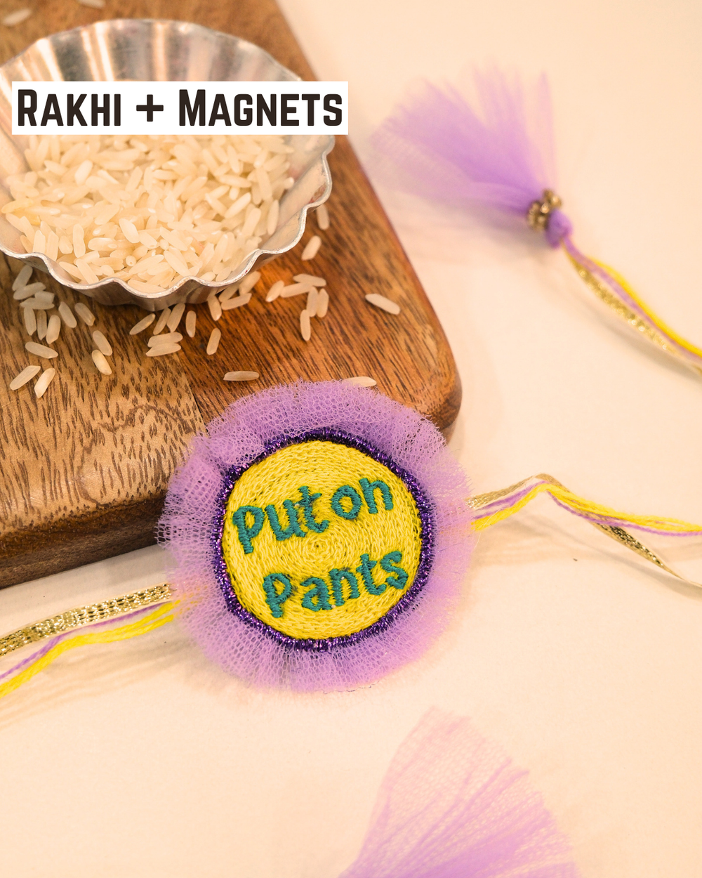 Put On Pants embroidered rakhi magnet placed beside a bowl of rice, styled for a fun Raksha Bandhan celebration.
