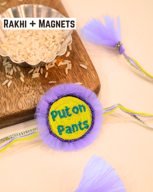 Put On Pants embroidered rakhi magnet placed beside a bowl of rice, styled for a fun Raksha Bandhan celebration.