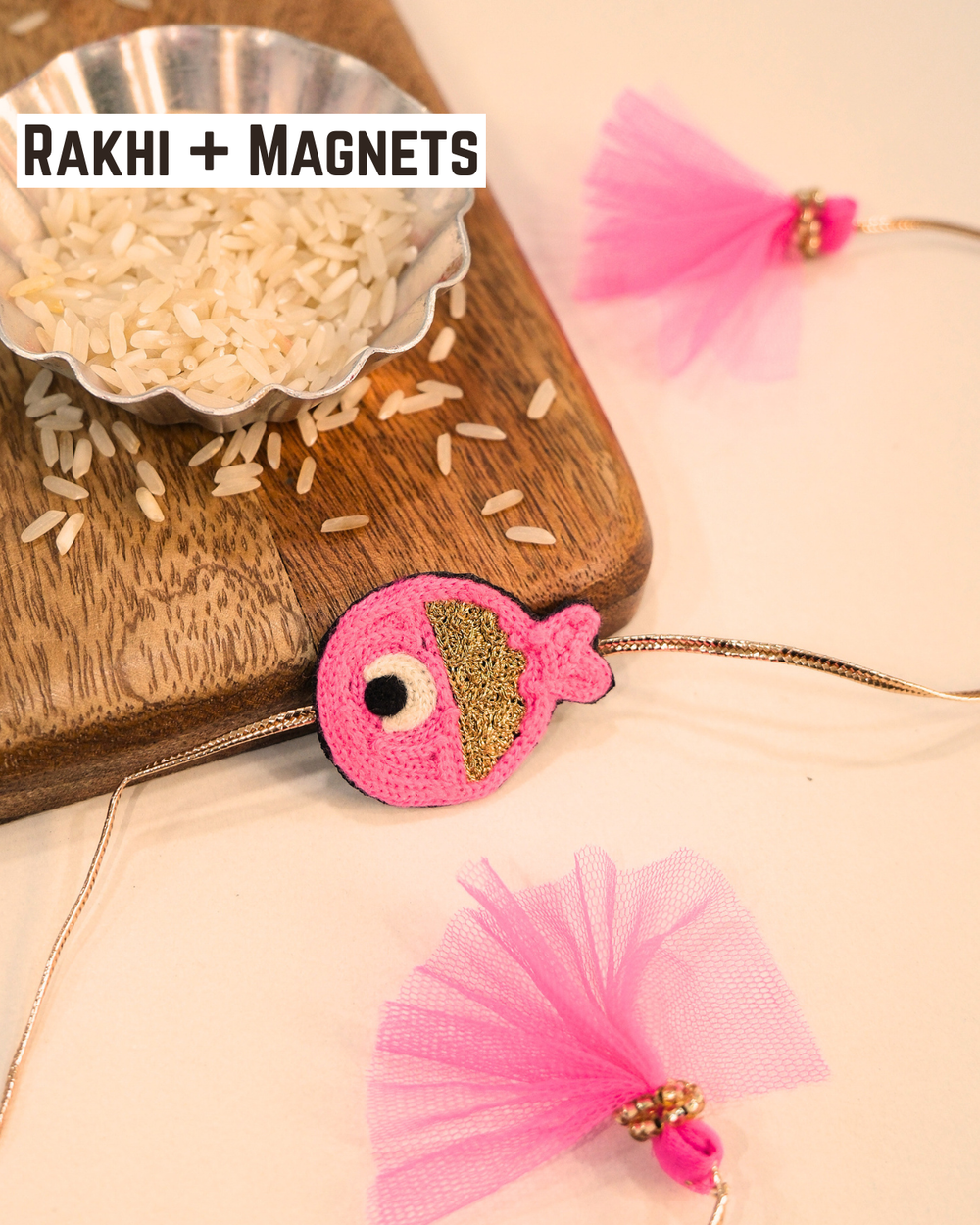 Cute Rakhi Magnet Fish displayed with soft pink threads and tassels, adding a playful ocean-inspired touch to Raksha Bandhan.