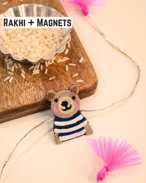 Panda embroidered rakhi magnet placed beside a bowl of rice, styled for a festive Raksha Bandhan celebration.