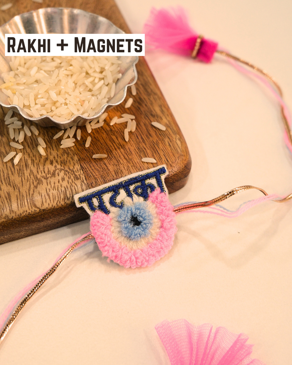 Pataka Evil Eye embroidered rakhi magnet placed beside a bowl of rice, styled for a festive Raksha Bandhan celebration.