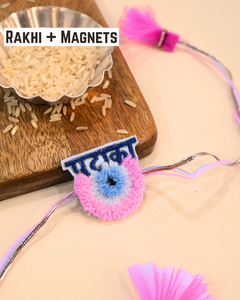 Pataka Evil Eye embroidered rakhi magnet placed beside a bowl of rice, styled for a festive Raksha Bandhan celebration.