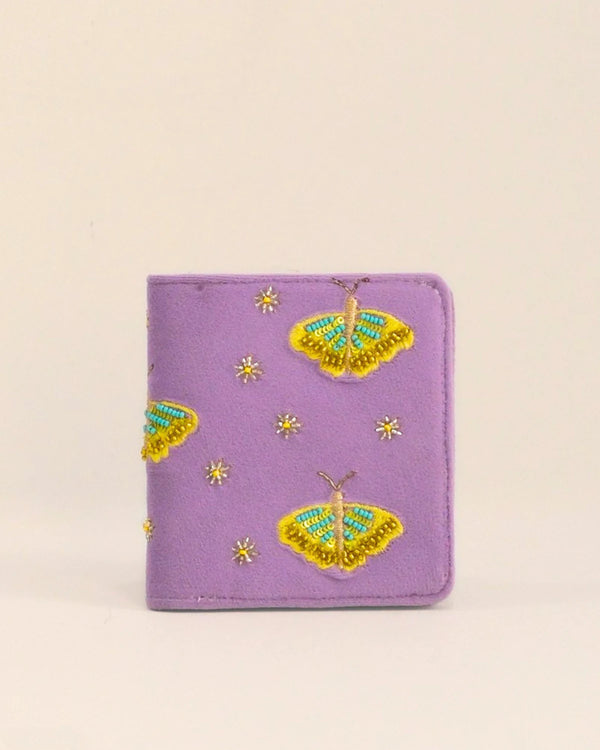 Purple wallet with butterfly designs on a beige background