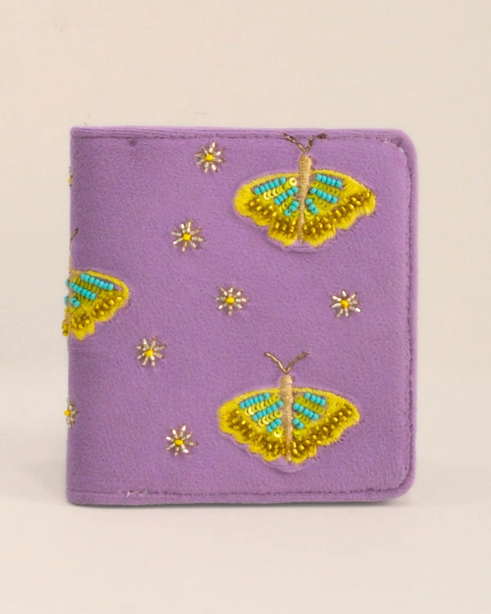 Purple wallet with butterfly designs on a beige background