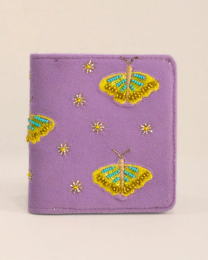 Purple wallet with embroidered yellow butterflies and flowers on a beige background