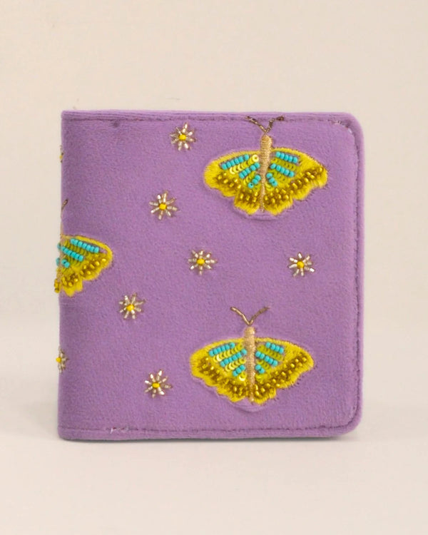Purple wallet with embroidered yellow butterflies and flowers on a beige background