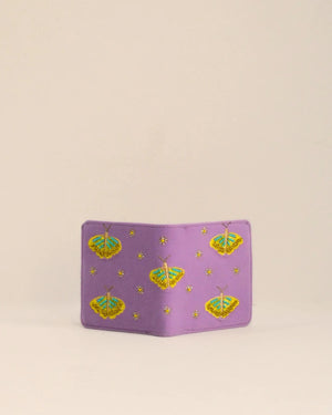 Purple pouch with butterfly pattern on a beige background