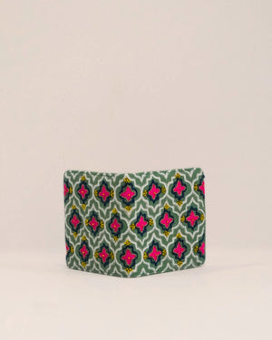 Green pouch with pink and blue pattern on a beige background