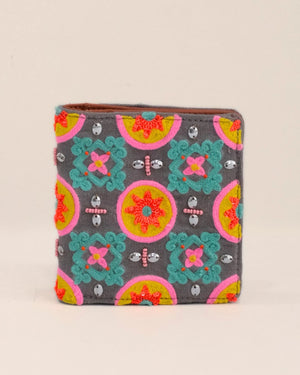 Colorful patterned wallet with decorative elements on a beige background
