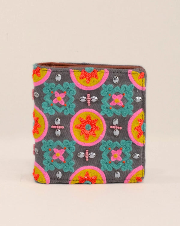 Colorful patterned wallet with decorative elements on a beige background