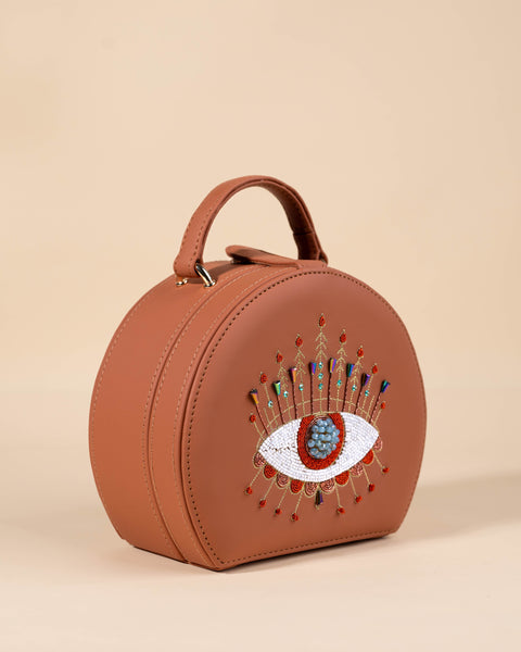 Tan evil eye bag with katdana, crystals, dabka, and symbolic embroidery for positive vibes