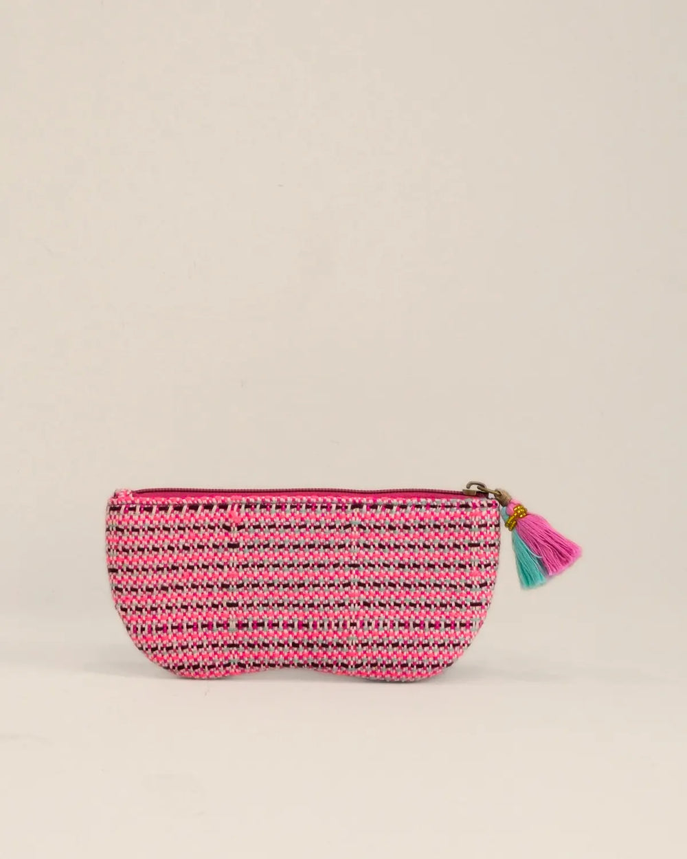 Pink pouch with heart designs and a tassel on a beige background