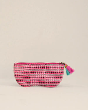Pink and black woven pouch with a tassel on a beige background