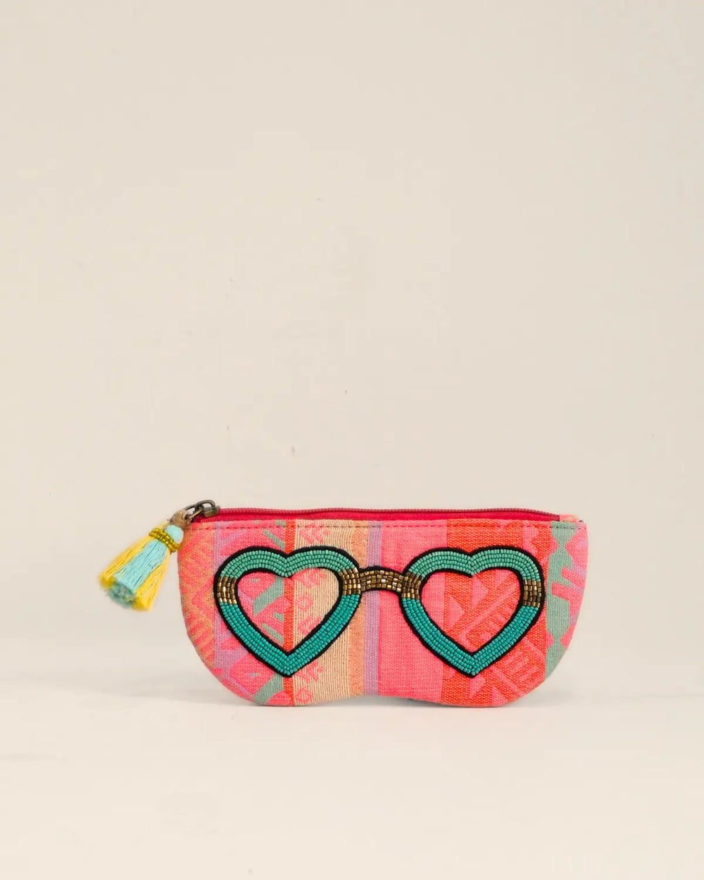 Small pouch with heart design and colorful pattern on a beige background