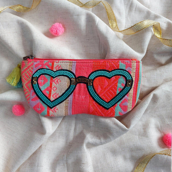 Decorative pouch with heart-shaped sunglasses design on a textured fabric background