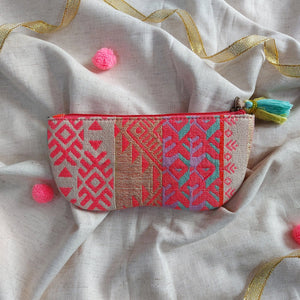 Embroidered pouch with colorful patterns on a textured fabric background