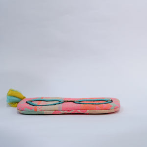Colorful woven pouch with a tassel on a light gray background