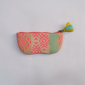 Small pouch with geometric pattern and colorful tassel on a light gray background